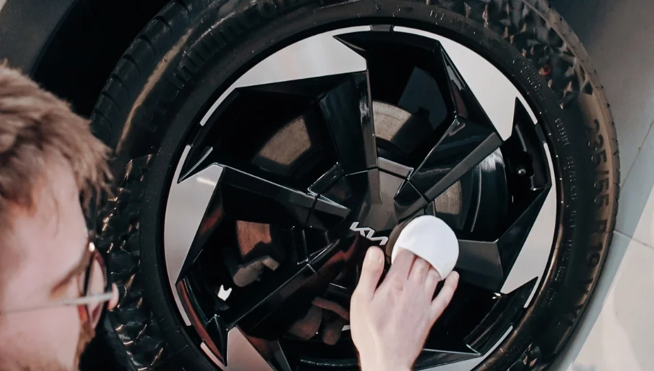 Ręczne polerowanie felgi Kia – detalizm serwisowy w trakcie czyszczenia mocno błyszczącej aluminiowej felgi SUV‑a